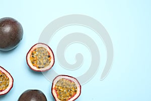 Fresh ripe passion fruits maracuyas on light background, flat lay. Space for text