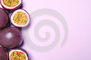 Fresh ripe passion fruits maracuyas on light pink background, flat lay. Space for text