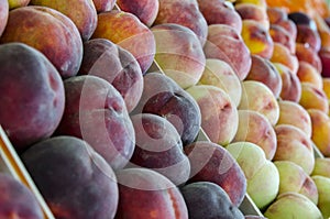 Fresh ripe peaches, nectarins on the counter at a local market. Selective focus