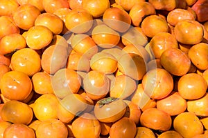 Fresh ripe persimmons placed on table in market.