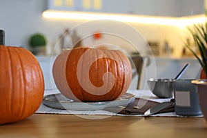 Fresh ripe pumpkins on table in kitchen. Halloween