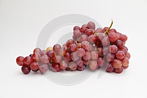 Fresh and ripe red grapes isolated in white background. Bunch of raw and juicy grapevines