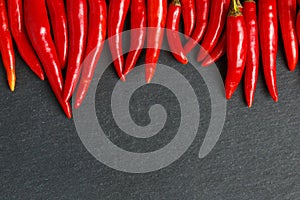 Fresh ripe red hot chili peppers on a black background