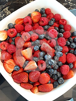 Fresh ripe red strawberries and blueberries in sieve