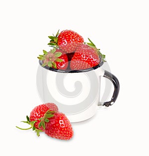 Fresh ripe red strawberries in enamel mug over white background