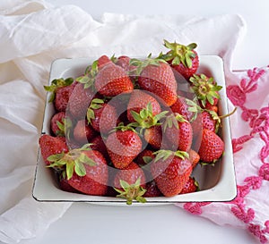 Fresh ripe red strawberries in a white iron plate