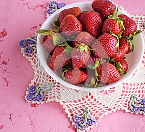 Fresh ripe red strawberries in a white round ceramic plate