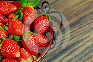 Fresh ripe strawberries in a basket on wooden background