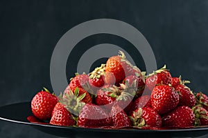 Fresh ripe strawberries Black background, side view. Red berries, seasonal fruits. Sweet mouth-watering strawberry