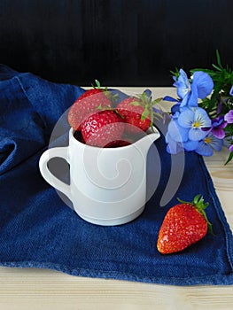 Fresh ripe strawberries in a ceramic jug