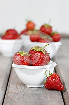 Fresh ripe strawberries in white ceramic bowl