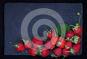 Fresh ripe strawberry on dark background, top view, copy space