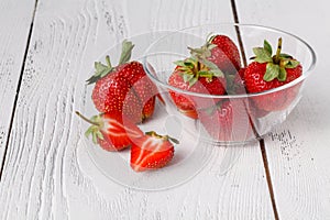 Fresh ripe strawberry in dish on white wooden table