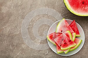 Fresh ripe striped sliced watermelon in the plate on grey background