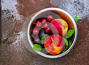 Fresh ripe summer berries and fruits, peaches, apricots, cherry and strawberry in a round plate