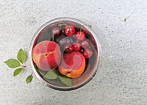 Fresh ripe summer berries and fruits, peaches, apricots, cherry and strawberry in a round plate