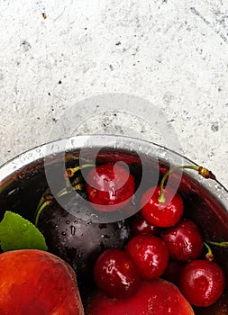 Fresh ripe summer berries and fruits, peaches, apricots, cherry and strawberry in a round plate