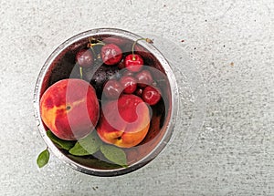 Fresh ripe summer berries and fruits, peaches, apricots, cherry and strawberry in a round plate