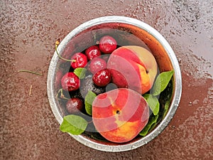 Fresh ripe summer berries and fruits, peaches, apricots, cherry and strawberry in a round plate