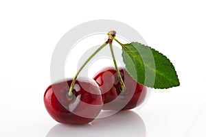 Fresh and ripe sweet cherry with green leaf close up