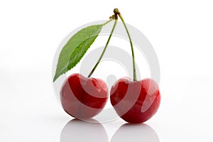 Fresh and ripe sweet cherry with green leaf close up