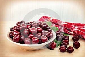 Fresh ripe sweet cherry in a plate on a light table