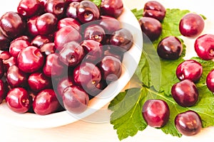 Fresh ripe sweet cherry in a plate on a light table