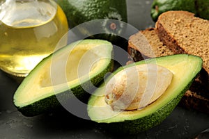 Fresh ripe tasty avocado and ingredients for sandwiches on a black graphite background. tropical fruit