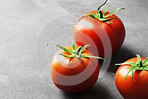 Fresh ripe tomatoes on a concrete background.