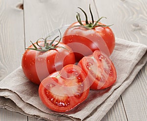 Fresh ripe tomatoes with halfs on wood table