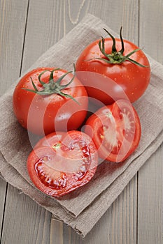 Fresh ripe tomatoes with halfs on wood table