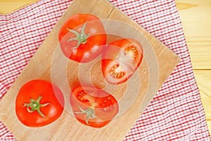 Fresh ripe tomatoes with halfs on wood table