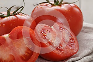 Fresh ripe tomatoes with halfs on wood table