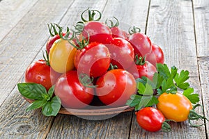 Fresh ripe tomatoes in a plate on a wooden table