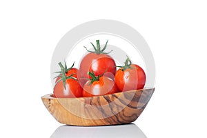 Fresh ripe tomatoes in wood bowl isolated on white background.