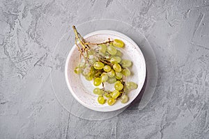 Fresh ripe white grape berries in wooden bowl on stone concrete background