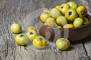 Fresh ripe yellow hawthorn fruits on wooden rustic background