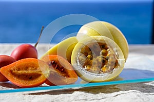 Fresh ripe yellow  passion fruit and tamarillo on blue sea background