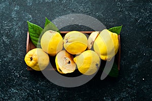 Fresh ripe yellow quince. Fruits in a wooden box.