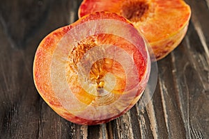 Fresh ripe yellow-red plums cut into halves on wooden background