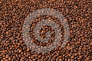 Fresh roasted coffee beans background. Selective focus. Copy space