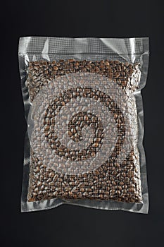 Fresh roasted coffee beans packed in vacuum sealed bag, gray background