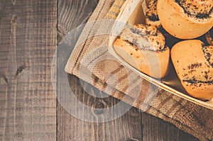 Fresh rolls with poppy a wooden box/fresh pastries concept: fresh rolls with poppy a box on a dark wooden background, top view and