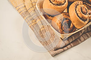 fresh rolls with poppy a wooden box/fresh pastries concept: fresh rolls with poppy a wooden box on a white background, top view