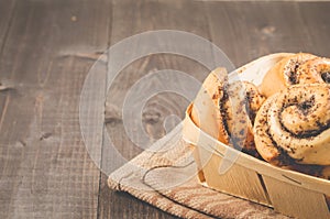 Fresh rolls with poppy a wooden box/fresh rolls with poppy a wooden box on a dark wooden background, with copy space