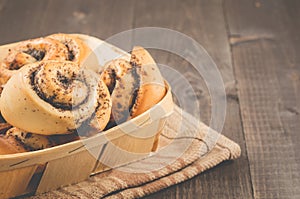 Fresh rolls with poppy a wooden box/fresh rolls with poppy a wooden box on a dark wooden background, selective focus