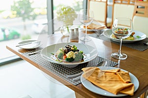 Fresh romantic breakfast table next to morning briliant light window, with beef, salmon fish, mashed potato, vegetable, red wine