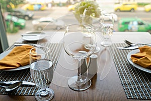 Fresh romantic breakfast table next to morning briliant light window with glasses prepare for the meal