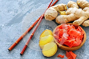 Fresh root, slices of pickled ginger and chopsticks.