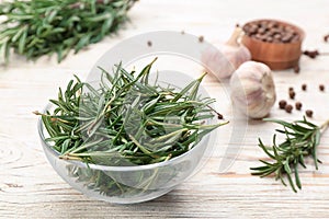 Fresh rosemary in glass bowl on white table